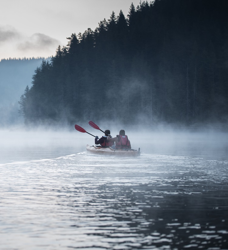 Young couple on kayaking adventure in mountain lake. content-image